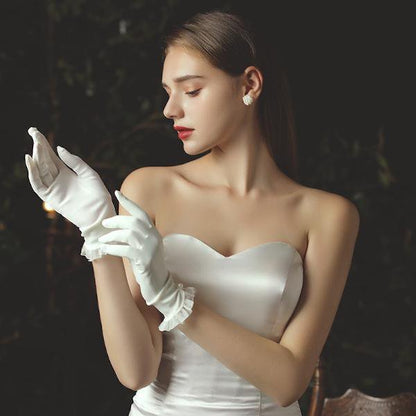 Delicate white bridal gloves with lace edges