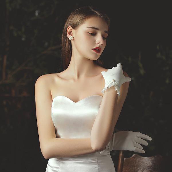 Delicate white bridal gloves with lace edges